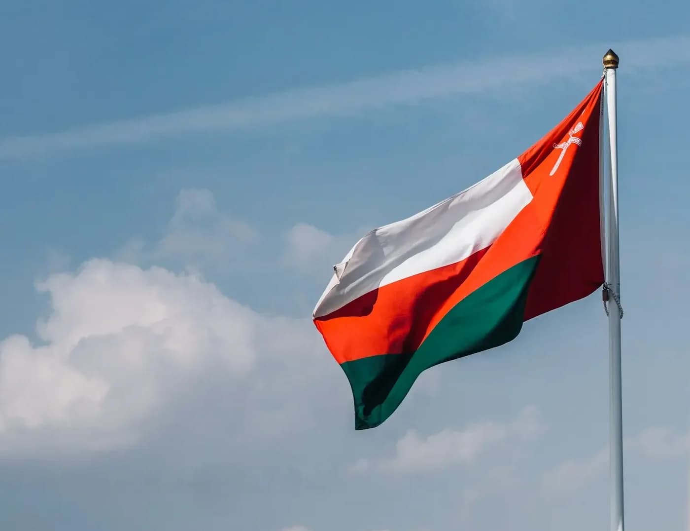 The flag of Oman flying above a fort